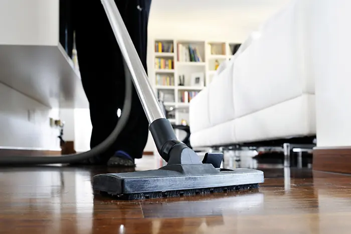 Maid vacuuming a floor
